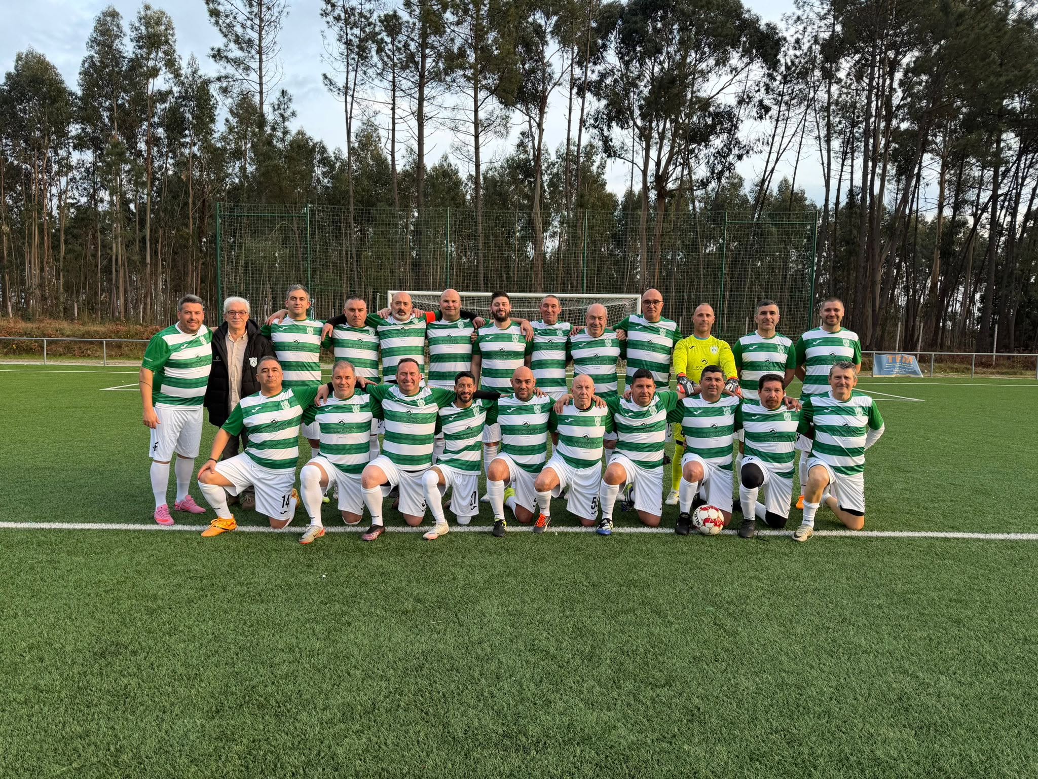 Equipa dos Leões da Beira Veteranos reunida no relvado, com o equipamento verde e branco.